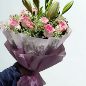 Hand-tied bouquet of 3 pink lilies and 20 pink roses wrapped in premium floral paper, available for fresh flower delivery in Delhi.